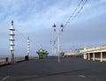 View along the pedestrian promenade in blackpool with traditional wooden shelters and lights with the town buildings in the