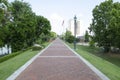 A view along the Riverwalk footpath in Augusta, Georgia,. With grass banks and trees on either side and a glimpse of the