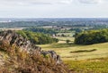 A view along the side of Precambrian rock outcrops towards the city of Leicester in Bradgate Park, Leicestershire, UK