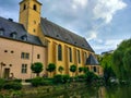 View of the Alzette river with St. John Church church of St. John or St. Jean du Grund at the background, in the Grund district Royalty Free Stock Photo