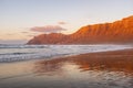 View of amazing beach during red sunset time. Ocean water and shore. Mountains in background with clear sky. Summer holiday Royalty Free Stock Photo