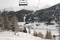 A view of an amazing beautiful village in the snow covered landscape and mountains and a cable car/lift in the alps switzerland in