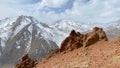 View of the amazing mountain landscape. Panorama of red rocky cliffs and snow-capped mountains. Beautiful nature of Kyrgyzstan. Royalty Free Stock Photo