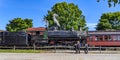 View of an Amish Father and His Sons Looking at an Old Steam Engine Warming Up Blowing Steam