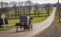 View of an Amish Horse and Buggy Traveling Down a Hill on a Rural Road on a December Day