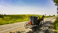 View of An Amish Horse and Buggy Traveling on a Rural Road Thru Farmlands