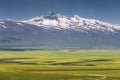 ancient extinct Aragats volcano and the fertile valley at its foot with agricultural lands sown in early spring in