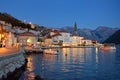 View of ancient picturesque city of Perast, Montenegro. Old medieval little town with red roofs and mountains on background of