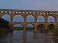 View of ancient Roman aqueduct Pont du Gard in the evening near town Vers-Pont-du-Gard, Occitanie, France with rocks. Royalty Free Stock Photo