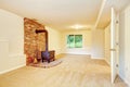 View of antique fireplace with brick wall in empty living room.