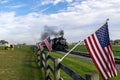 View of an Antique Steam Passenger Train Approaching With a Line of American Flags