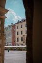 View from arcades on Krakow main square or Glavny Rynek on a summer day. Visible chairs and bars next to old houses