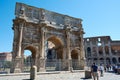 View of the Arch of Constantine in Rome, with the Coliseum in the background, surrounded by tourists Royalty Free Stock Photo