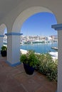 View through arch to Duquesa port and mountains Royalty Free Stock Photo