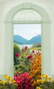 View through arched door, colorful flower bed alpine mountain lake bavaria