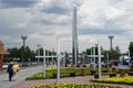 View of the architectural stele with the city`s coat of arms, modern street lamps and flower beds with yellow flowers. July, 16, Royalty Free Stock Photo