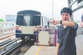 View of asian  man stand and looking at his watch while waiting for something or worrying about time. Motion train as background. Royalty Free Stock Photo