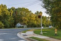 View of an asphalt road with stoplights and green trees on blue sky background. North Carolina. Royalty Free Stock Photo