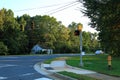 View of an asphalt road with stoplights and green trees on blue sky background. North Carolina Royalty Free Stock Photo