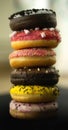 View of assortment colorful frosted delicious tasty stacked doughnuts. Colored sprinkle glazed donuts with marshmallow and
