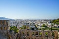 View of Athens cityscape through ancient stone theatre seeing lowrise white buildings architecture, mountain, trees and clear blue Royalty Free Stock Photo