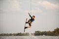 View of athletic male wakeboarder jumping high over river water Royalty Free Stock Photo