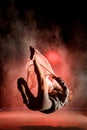 View of athletic woman in the air falling on trampoline in the dark time.