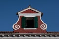 View of an atique window in an Italian house in Burano, Italy against a clear blue sky background Royalty Free Stock Photo