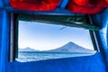 View of Atitlan & Toliman volcanoes through open boat window, Lake Atitlan, Guatemala, Central America