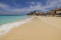 View of Atlantic ocean with people lying on sun loungers under sun umbrellas on sandy Eagle beach.