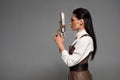 View of attractive steampunk woman holding vintage pistol isolated on grey