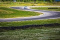 View of autodrome race circuit racetrack with a line of cars driving and racing, with audience and during rally autocross racing