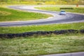 View of autodrome race circuit racetrack with a line of cars driving and racing, with audience and during rally autocross racing