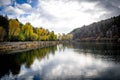The view of autumn trees and the reflection of clouds on the lake. Royalty Free Stock Photo