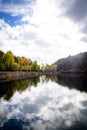 The view of autumn trees and the reflection of clouds on the lake. Royalty Free Stock Photo