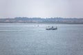 View of Aveiro river with private recreational boat with people sailing. Day with clouds and background with typical vegetation Royalty Free Stock Photo