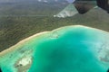 View of wing, azure lagoon and yellow sandy beach from an airplane window, Isle of Pines, New Caledonia. Oceania. Royalty Free Stock Photo