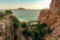 View of an azure sea lagoon with a beach and green trees at the bottom of a deep canyon Royalty Free Stock Photo