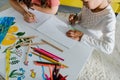 View of babysitter drawing with cute kid in living room Royalty Free Stock Photo