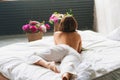 view from back. beautiful topless woman with a bouquet of peonies on the bed. Royalty Free Stock Photo