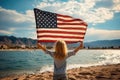 View from the back child holds the American flag of the USA on the background of the lake