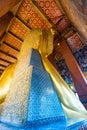 view from the back of gold lying Buddha in a temple