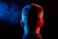 A view from the back on the head of a man in a shirt smoking a v Royalty Free Stock Photo