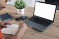 View from back of man using laptop and writing in notebook. modern office. Mockup White screen laptop, computer Royalty Free Stock Photo