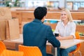 View from back to unrecognizable man and attractive blonde woman having date sitting at table looking at each other in Royalty Free Stock Photo