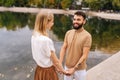 View from back of unrecognizable smiling young woman to cheerful bearded man standing holding hands with girlfriend Royalty Free Stock Photo