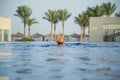 View from back of white european tourist swimming in blue water