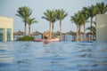 View from back of white european tourist swimming in blue water