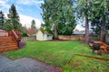 View of a back yard with green grass and small shed.