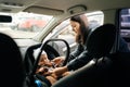 View from backseat of pretty loving mother fasting infant baby boy on front passenger seat with back to engine. Cute Royalty Free Stock Photo